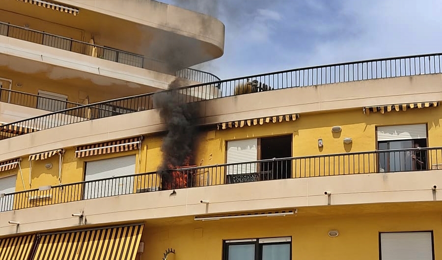 Un policía local rescata en brazos a una vecina con movilidad reducida durante un incendio en el edificio Toscamar