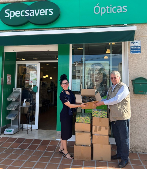Maria Georgieva, asistente de ventas en Specsavers Ópticas Jávea, entregando a Malcolm Saunders del Club de Leones de Calpe y Benissa las cajas de gafas