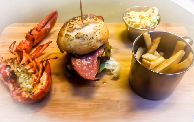 La hamburguesa acompañada por medio bogavante especialidad de la casa.